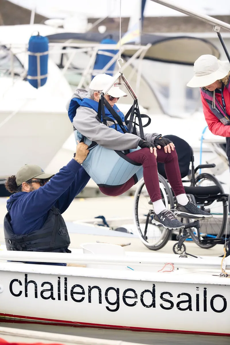 Volunteer helping a sailor into the boat
