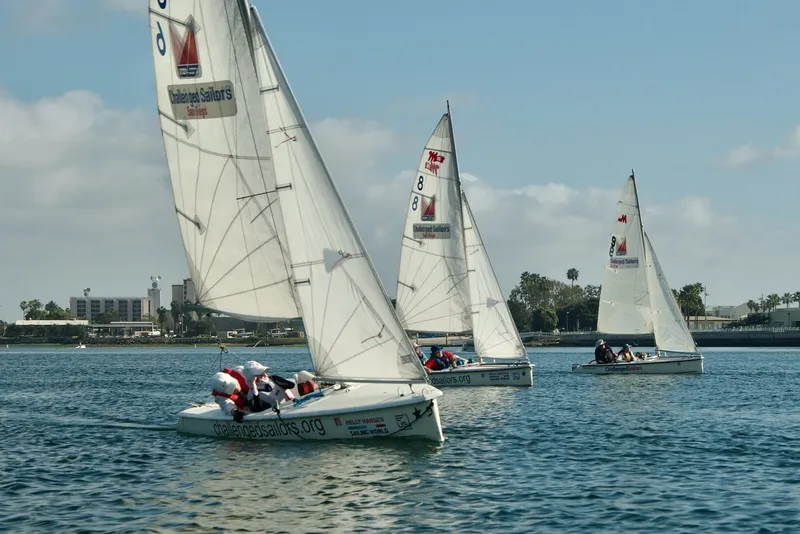 Fleet of Challenged Sailors boats racing on the bay